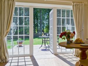 an open living room with sliding glass doors and a table at Curlew Cottage in Meigle +6 photos