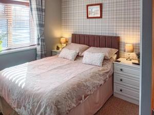 a bedroom with a bed and two night stands and a window at Stag Lodge in Auchterarder +15 photos