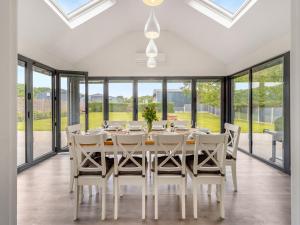 a dining room with a table and chairs and large windows at Orchard Barns - Uk47200 in Stapleton