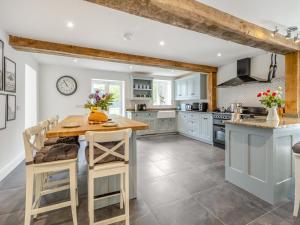 a kitchen with blue cabinets and a wooden table at Orchard Barns - Uk47200 in Stapleton