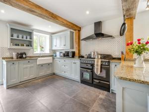 a kitchen with white cabinets and a stove at Orchard Barns - Uk47200 in Stapleton