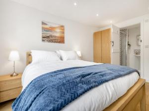 a bedroom with a large bed with a blue blanket at Orchard Barns - Uk47200 in Stapleton +16 photos