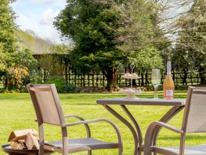 two chairs and a table with a bottle of wine at Granary Barn - Ukc5405 in Banham
