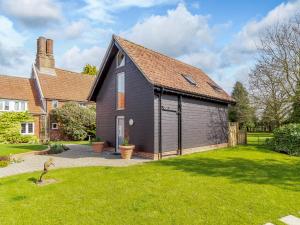 a black house with a garage in a yard at Granary Barn - Ukc5405 in Banham