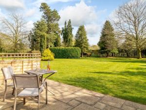 a patio with a table and chairs and a lawn at Granary Barn - Ukc5405 in Banham