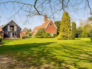 a house on a green lawn with a tree at Granary Barn - Ukc5405 in Banham +17 photos