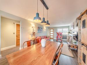 a dining room and living room with a wooden table at Wynmine Cottage in Esh