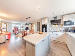 a kitchen and living room with white cabinets and a table at Wynmine Cottage in Esh