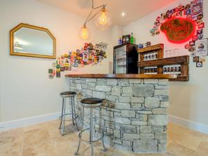 a bar with stools in front of a stone wall at Old Barn 1 - Uk48477 in Ferndown