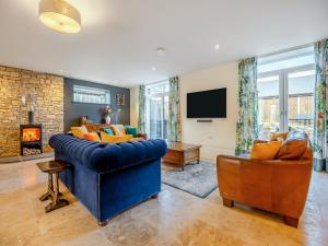 a living room with a blue couch and a fireplace at Old Barn 1 - Uk48477 in Ferndown +18 photos