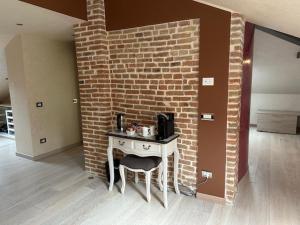 a brick wall with a table and a chair in a room at Villa Simona in Voghera
