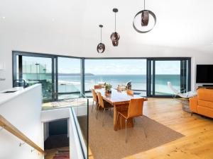 a dining room and living room with a view of the ocean at Cyan in Mortehoe