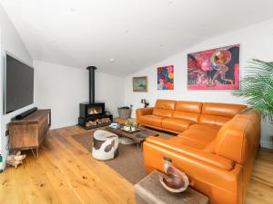 a living room with an orange couch and a fireplace at Cyan in Mortehoe