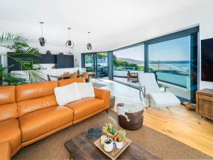 an orange couch in a living room with a view at Cyan in Mortehoe
