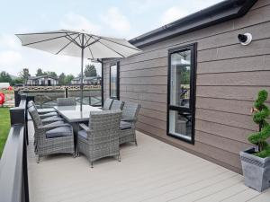 a patio with a table and chairs and an umbrella at Transporter Lodge - Ukc4060 in Nunthorpe