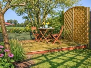 a patio with two chairs and a table and a fence at The Barn in Cantley