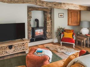a living room with a television and a fireplace at The Nook - Uk44735 in Tallentire