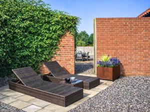 a patio with two wicker chairs and a table at South Barn in Heydon