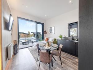a kitchen and living room with a table and chairs at Cadnant Lodge 2 - Uk42795 in Llangefni