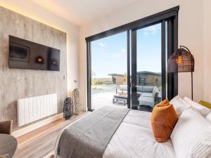 a bedroom with a bed and a large sliding glass door at Cadnant Lodge 2 - Uk42795 in Llangefni