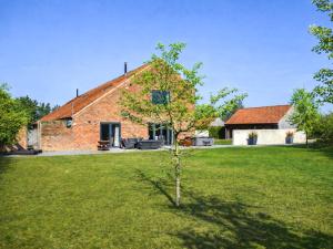 a small tree in front of a brick building at South Barn in Heydon