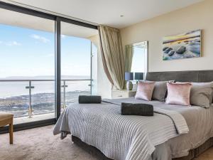 a bedroom with a large bed with a large window at Apartment 22, Horizon View in Westward Ho