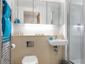 a bathroom with a toilet and a sink and a mirror at Apartment 22, Horizon View in Westward Ho