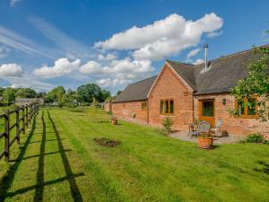 a brick house with a yard and a fence at Courtyard Lodge in Edwinstowe