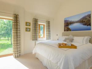 a bedroom with a bed with a tray of fruit on it at Courtyard Lodge in Edwinstowe