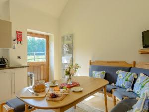 a living room with a table and a couch at Courtyard Lodge in Edwinstowe