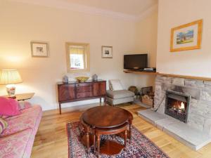 a living room with a fireplace and a tv at Gardeners- Uk7233 in Kirkmichael