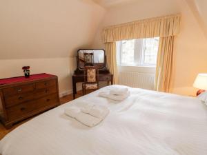 a bedroom with a white bed with two towels on it at Gardeners- Uk7233 in Kirkmichael +6 photos