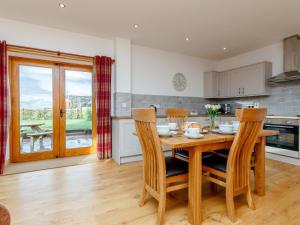 a kitchen and dining room with a wooden table and chairs at The Old Laundry - Uk12136 in Hewelsfield