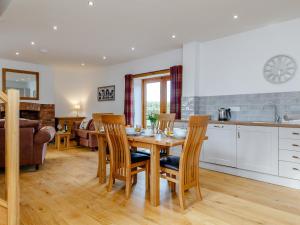a kitchen and living room with a wooden table and chairs at The Old Laundry - Uk12136 in Hewelsfield