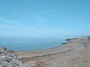 a rocky beach with a row of posts in the water at Helygen in Talybont
