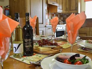 a table with a bottle of wine and a bowl of food at Helygen in Talybont