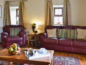 a living room with a leather couch and a table at Helygen in Talybont