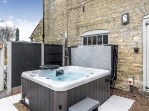 a hot tub in front of a building at The Retreat in Sudbrooke