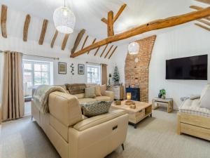 a living room with a couch and a tv at The Retreat in Sudbrooke +14 photos
