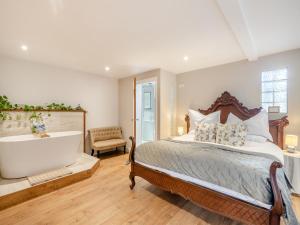 a bedroom with a large bed and a bath tub at The Cartlodge - Ukc1039 in Hickling +4 photos