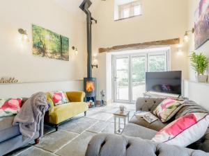 a living room with two couches and a fireplace at Alton Hall Cottage in Ashover +25 photos