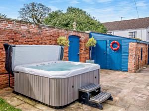 a hot tub sitting in a yard next to a building at Pengethley Manor - Uk39045 in Peterstow