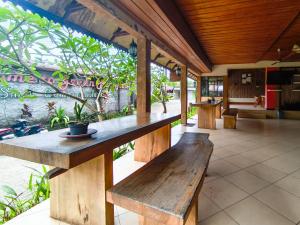 a wooden table and benches on a patio at The Lavana Green Asri Cottage in Senggigi