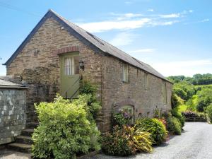 a brick house with a green door at Meadow Mews in Chillington