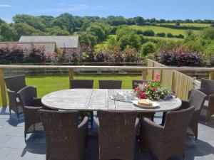 a table and chairs on a patio with a view at Meadow Mews in Chillington +15 photos