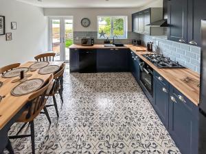 a kitchen with blue cabinets and a table with chairs at No 1 Fox Burrow-Uk44306 in Lenwade