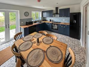 a kitchen with a wooden table with chairs in it at No 1 Fox Burrow-Uk44306 in Lenwade