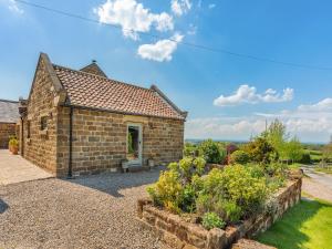 a brick house with a garden in front of it at The Gin Gang in Whorlton