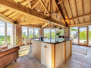 an open kitchen with wooden ceilings and windows at The Gin Gang in Whorlton