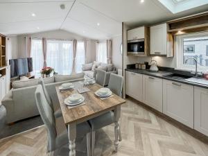 a kitchen and living room with a wooden table in a kitchen at Reed Roost - Uk37726 in Skegness